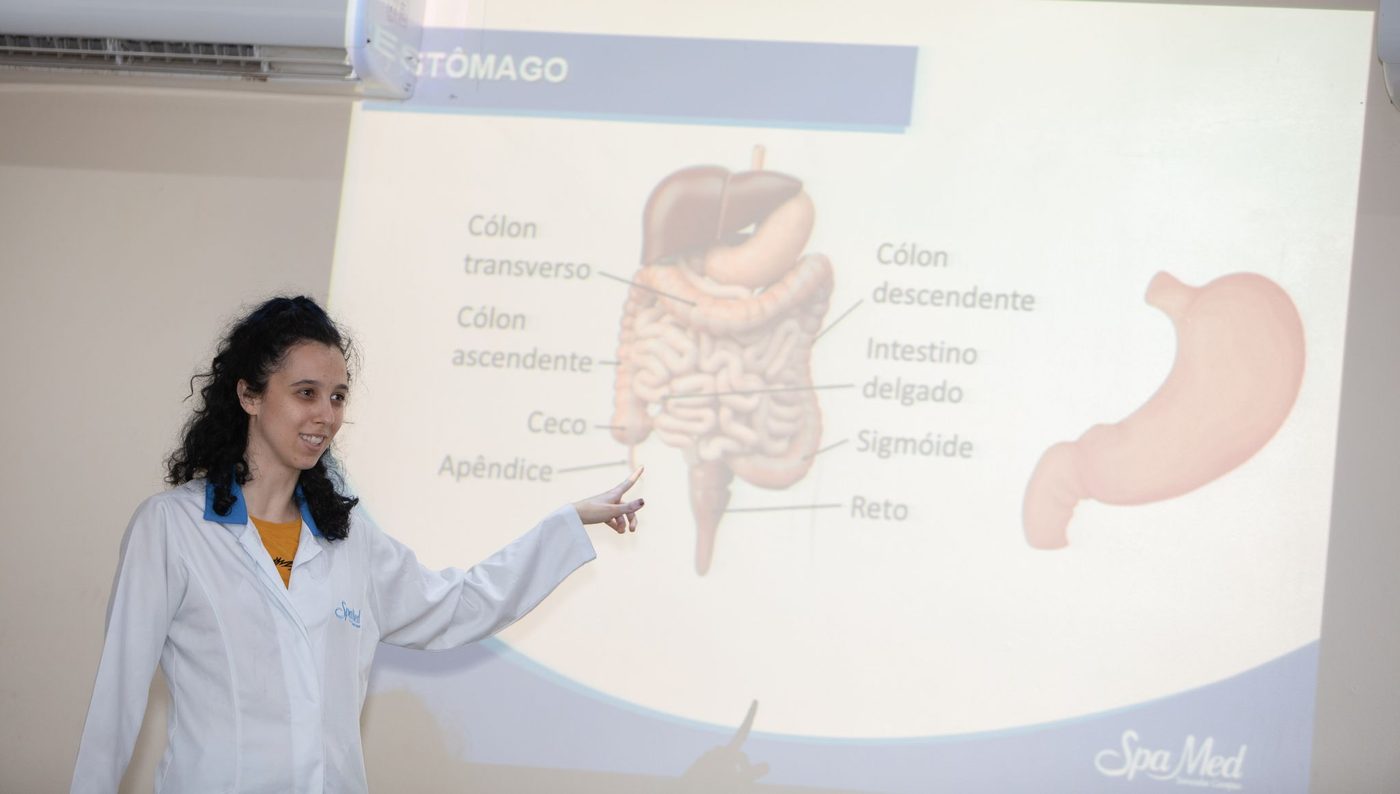 Nutricionista explicando o sistema digestório em uma aula