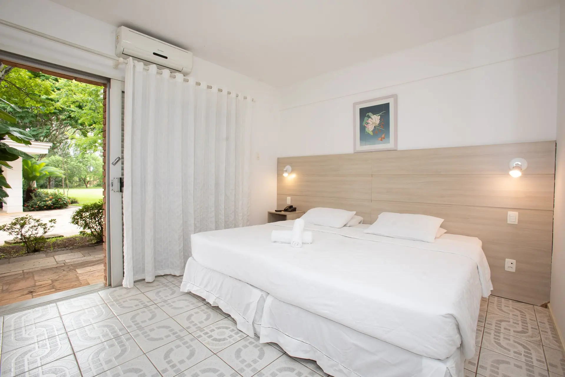Quarto do Apartamento Superior do Spa Med, com camas de solteiro e porta aberta para o jardim