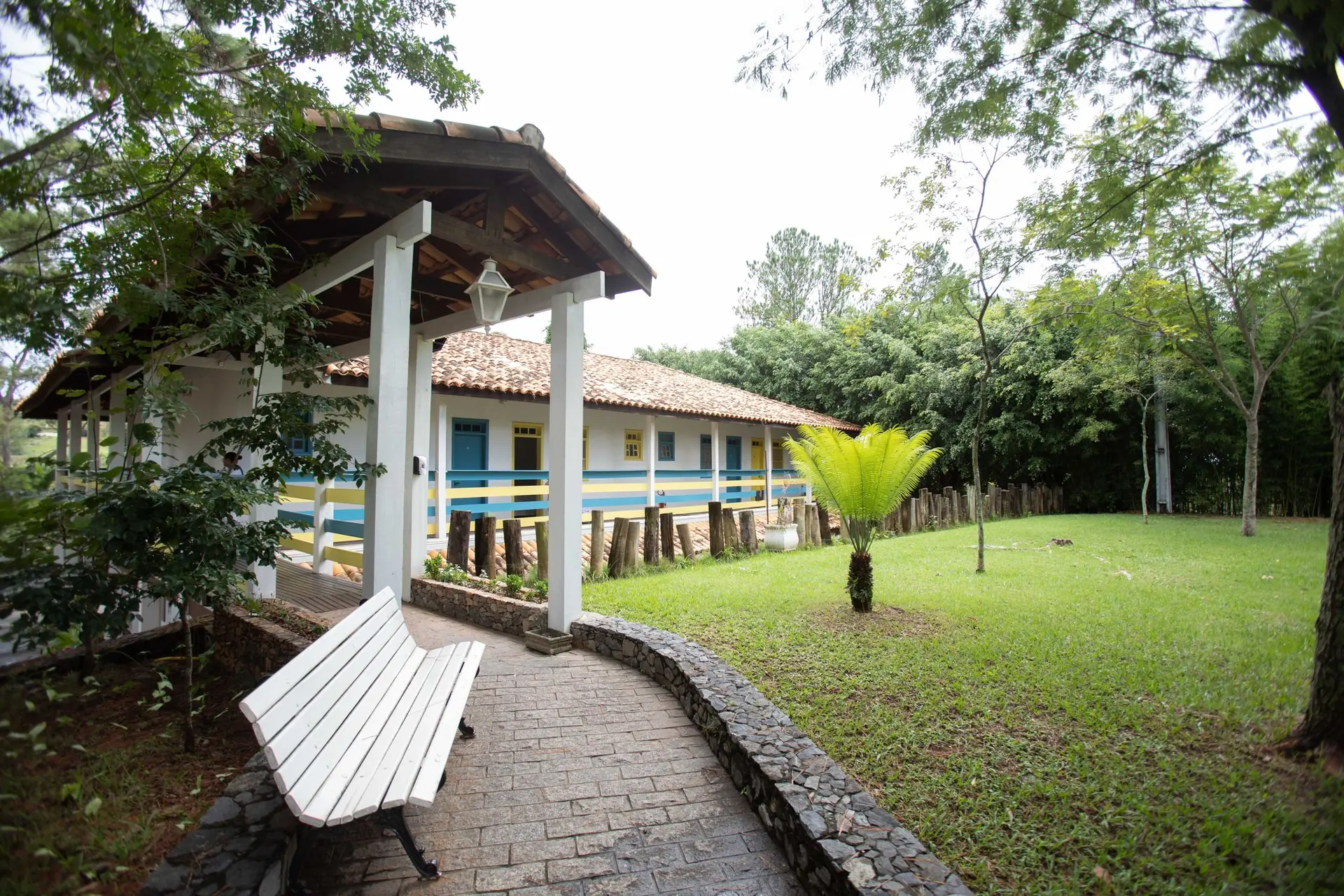 Fachada da Colonial Baiana do Spa Med, com varanda coberta e faixas azul e amarela
