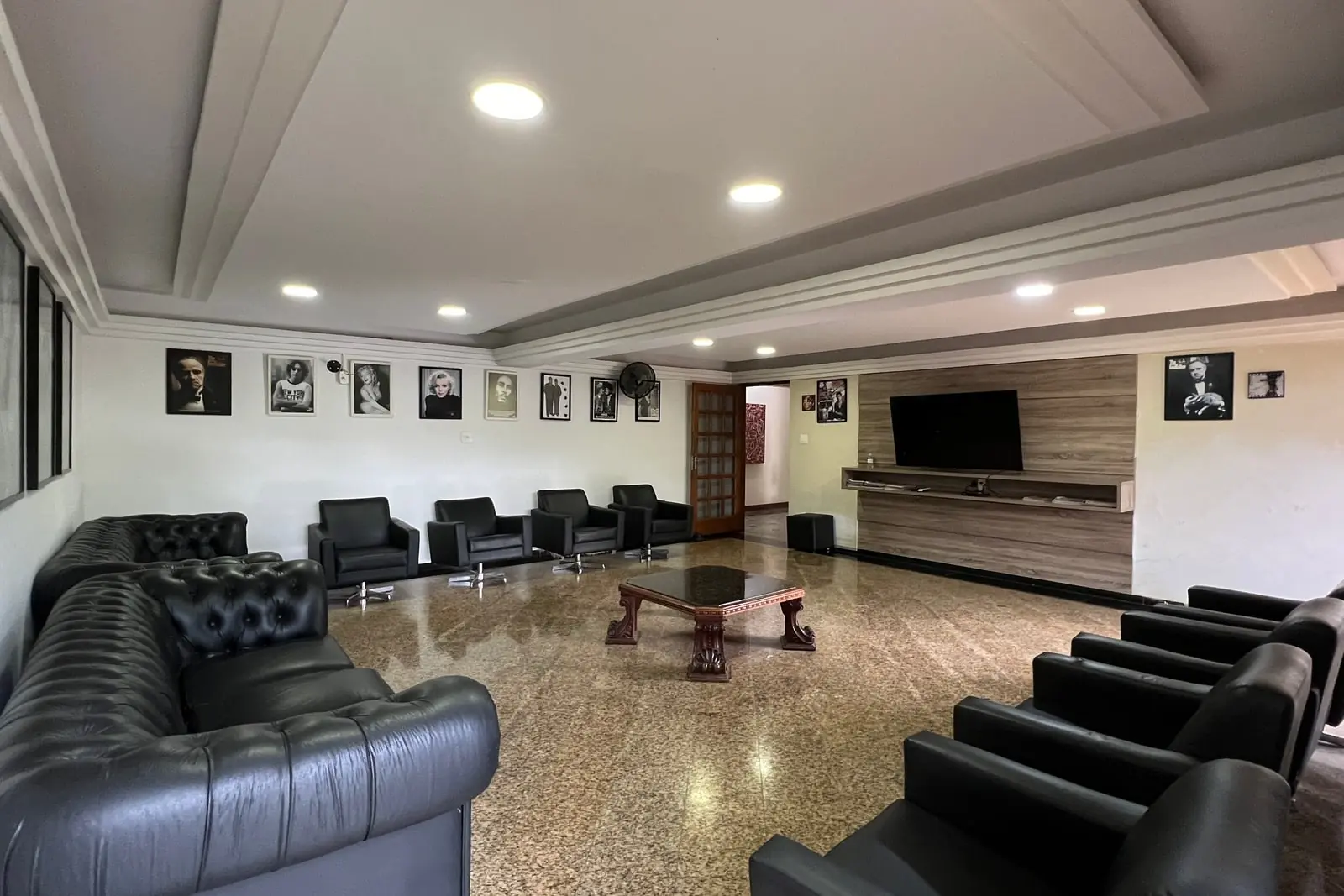 Sala de home theater do Spa Med, com poltronas de couro e a tela na parede