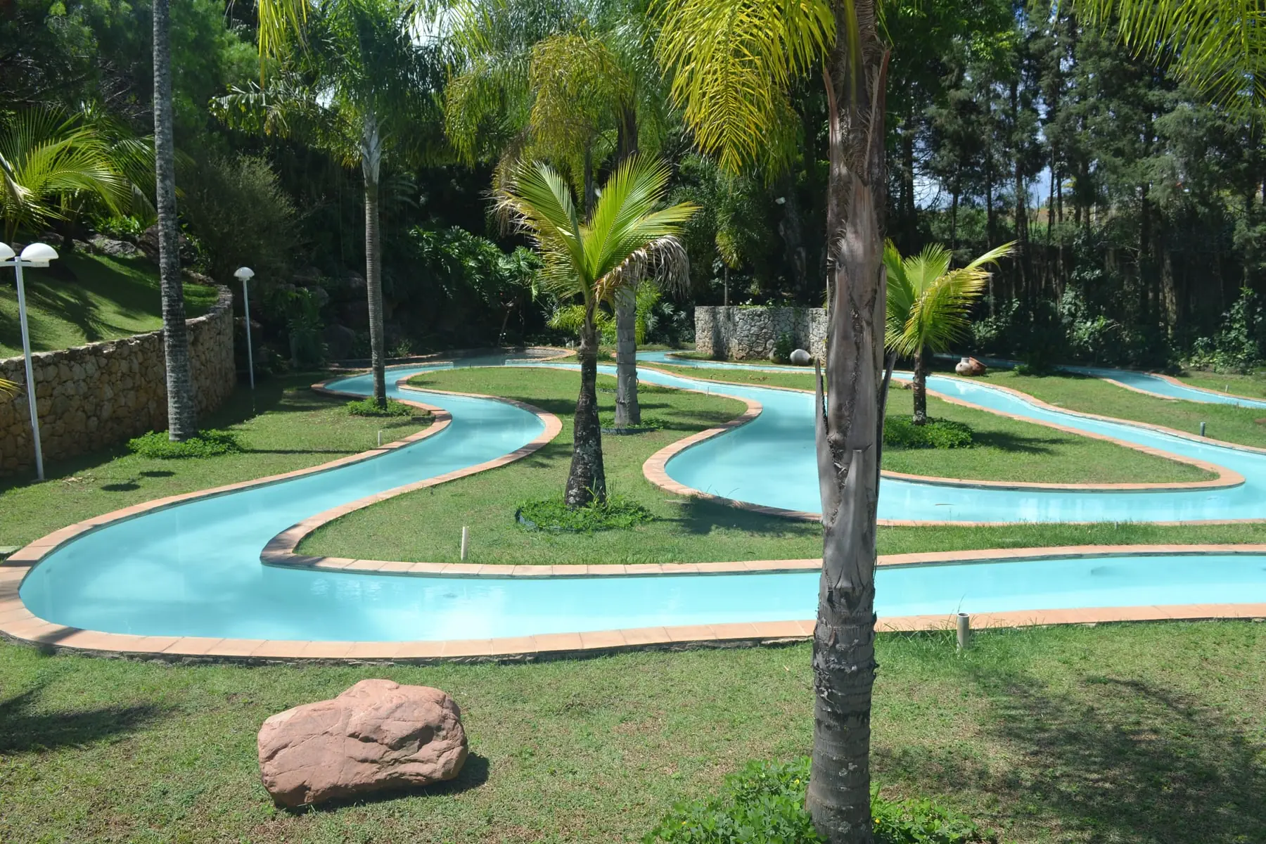 Caminho das Águas do Spa Med, com o percurso azul serpenteando entre palmeiras e gramado