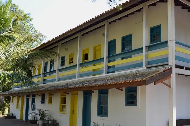 Bloco Colonial Baiana de dois andares, com varanda corrida, esquadria azul e detalhe amarelo