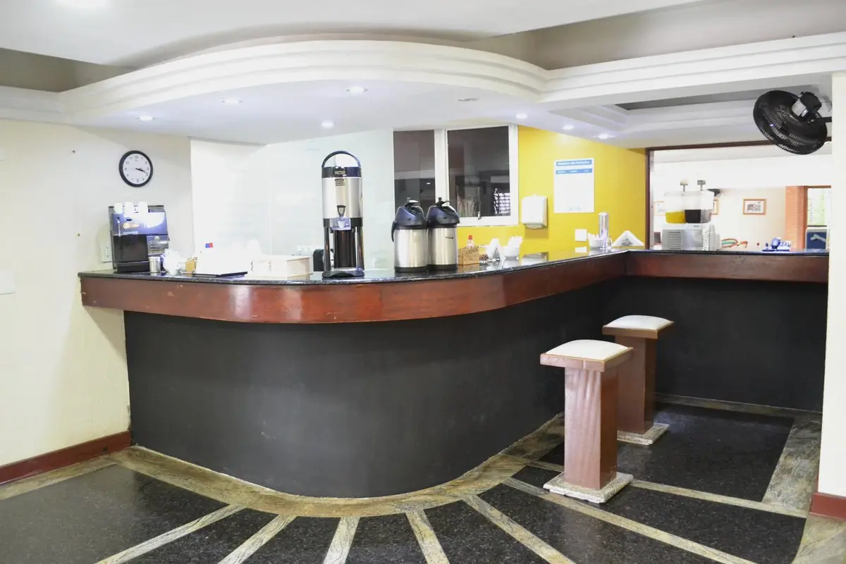 Balcão do diet bar com garrafas térmicas, máquina de café e utensílios sobre a bancada