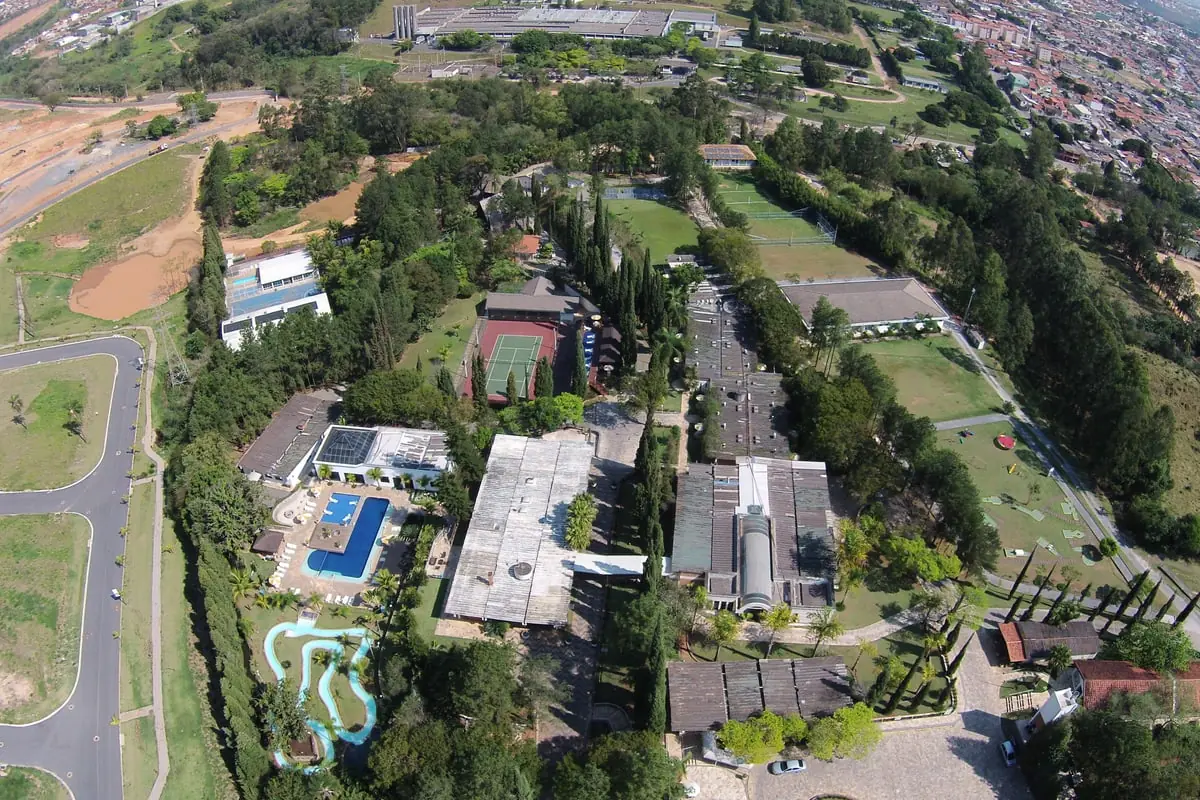 Vista aérea recente do Spa Med, com os blocos, as piscinas e a quadra entre a mata