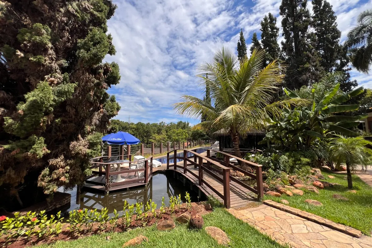 Lago com a ponte de madeira, o quiosque e a mata em volta
