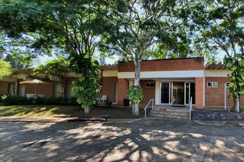 Suíte Master com duas camas de casal, roupões dobrados e quadro emoldurado na parede